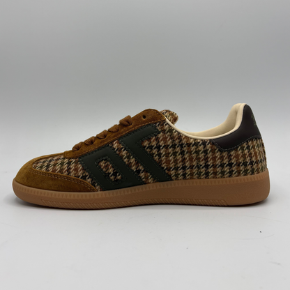 A low-top sneaker featuring a brown and beige houndstooth pattern on the upper, brown suede overlays, a black side stripe detail, and a brown gum sole, shown against a neutral gray background.