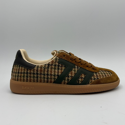 A single low-top sneaker shown in profile against a neutral gray background. The shoe features a brown and beige houndstooth pattern on the upper, dark green suede side stripes, a brown suede toe cap, and a thick brown gum sole with 'BACK 70' printed on the side.