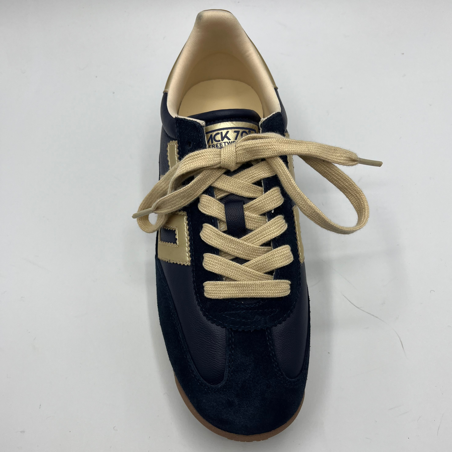 Navy blue sneaker with beige laces on a white background