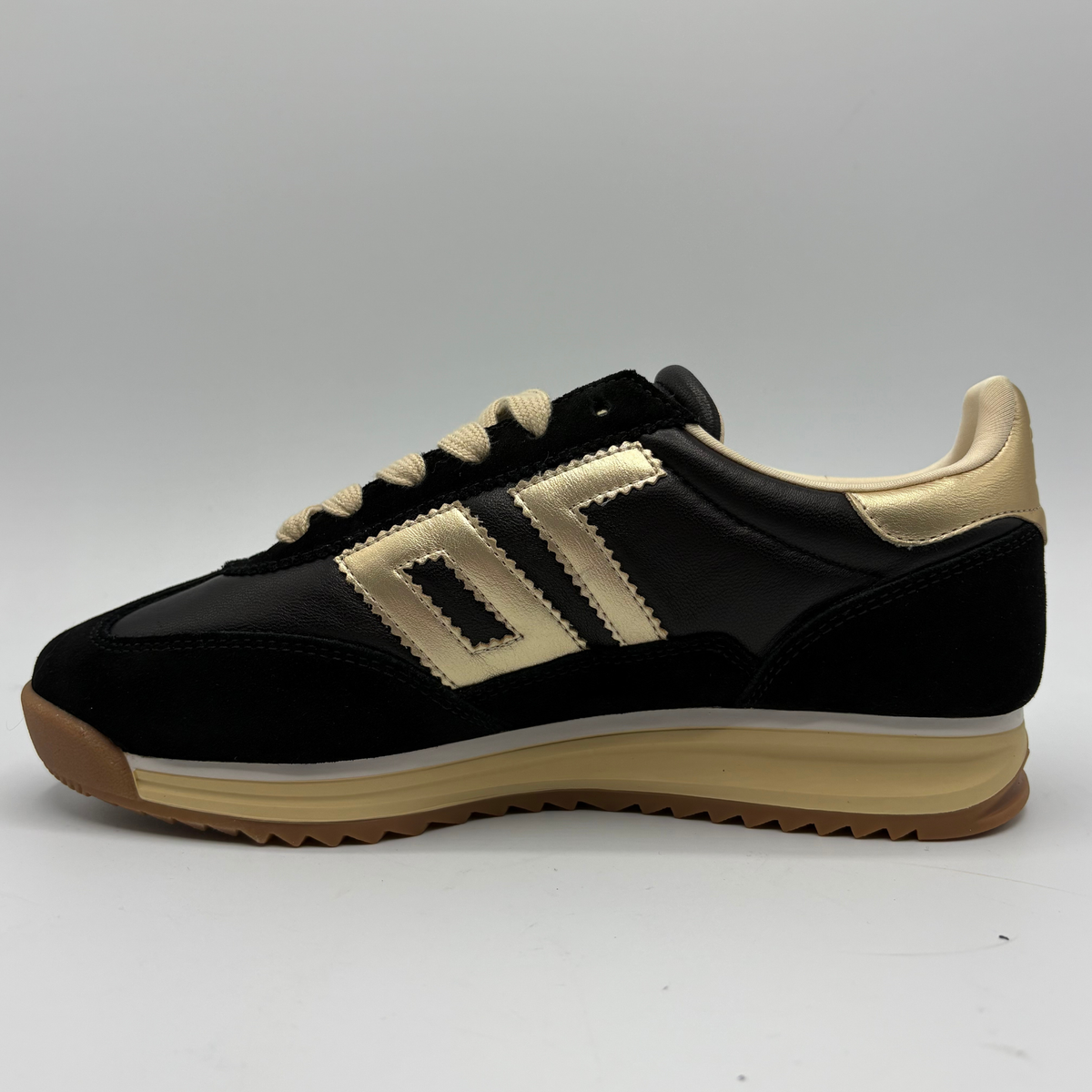 Left facing view of a black leather and suede sneaker with a gold “70” on the side