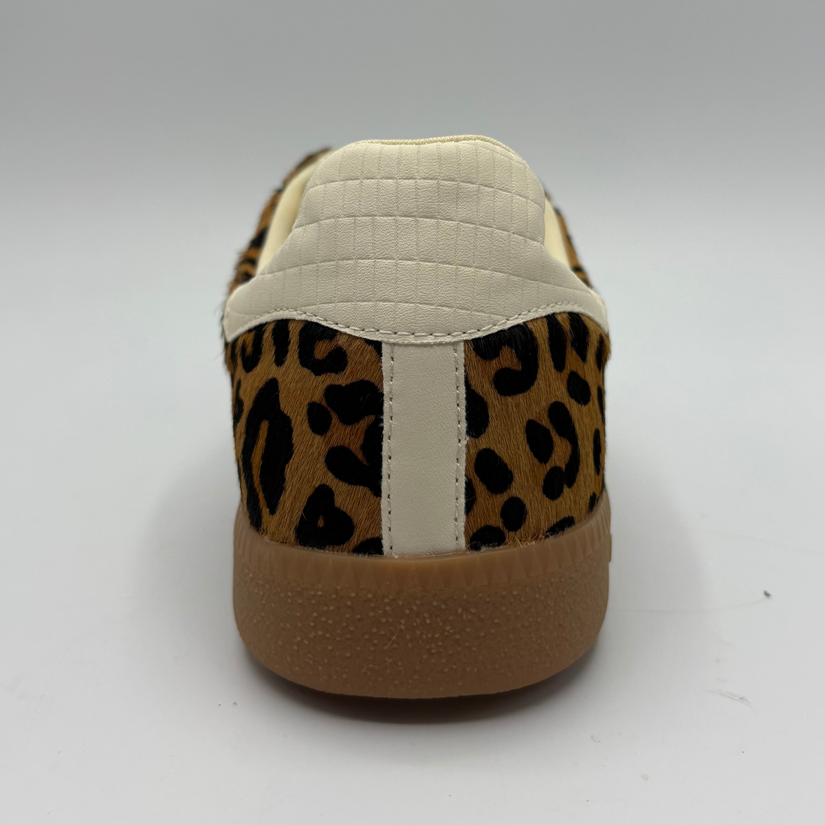 A low-top sneaker featuring a brown and black leopard print pattern on the upper, cream-colored “70”, a cream collar lining, and a brown gum sole with 'BACK 70' embossed on the heel.