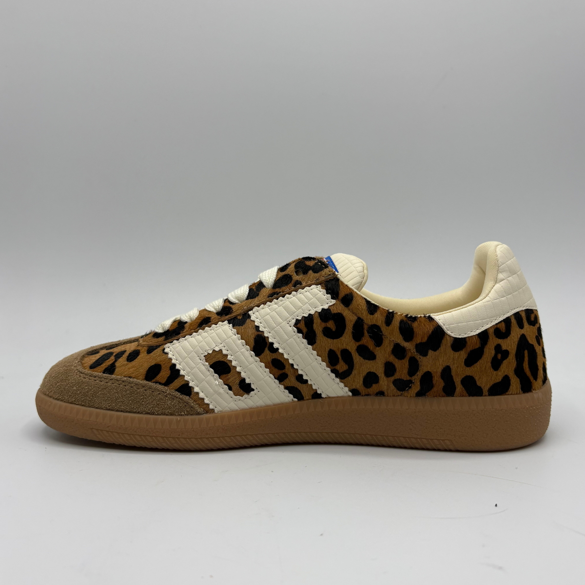 A low-top sneaker featuring a brown and black leopard print pattern on the upper, cream-colored “70”, a cream collar lining, and a brown gum sole with 'BACK 70' embossed on the heel.
