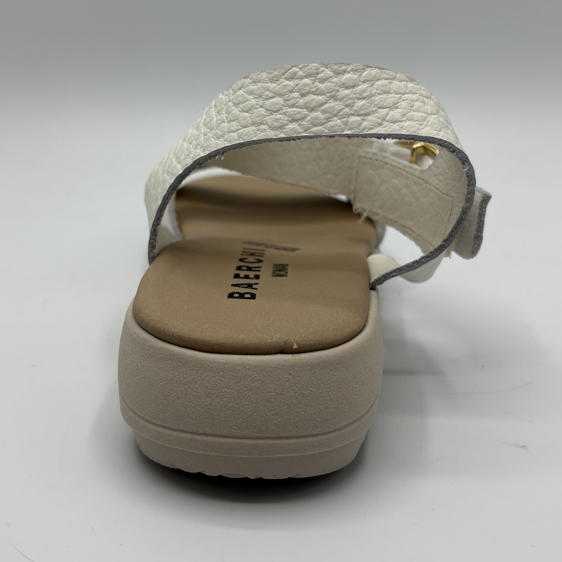 White sandal with textured strap on a white background