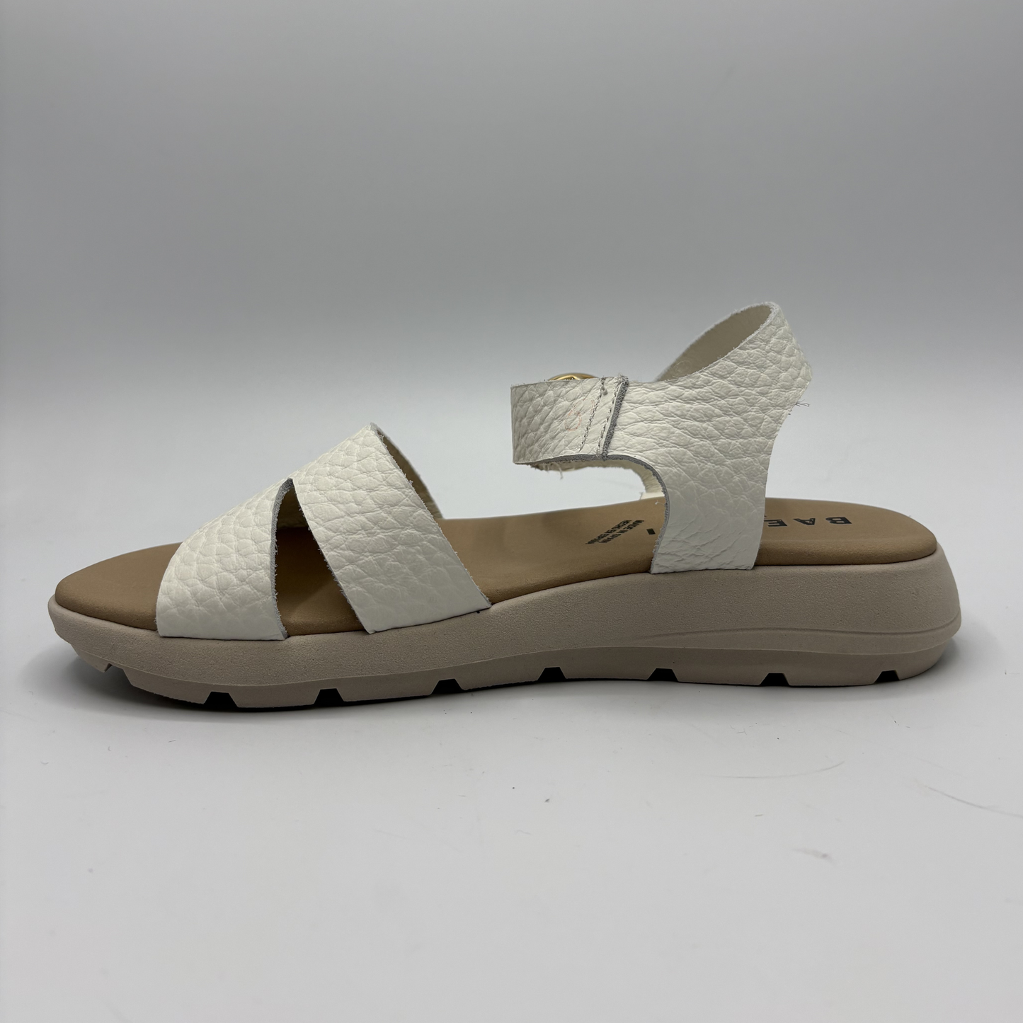 White sandal with brown sole on a gray background