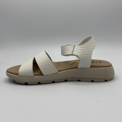 White sandal with brown sole on a gray background