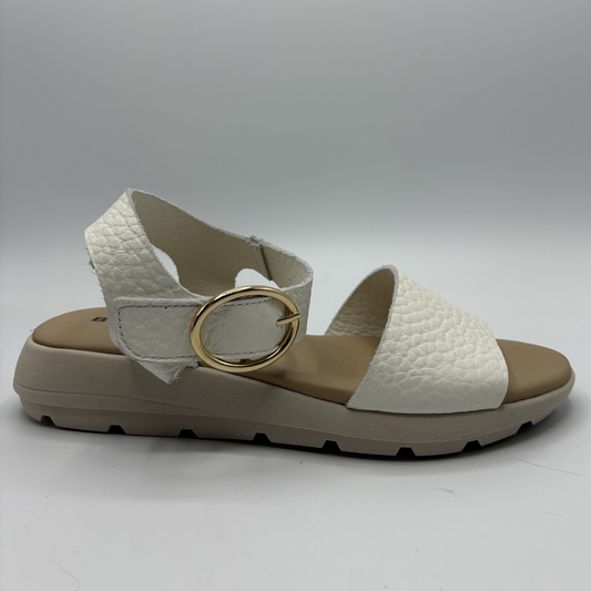 White sandal with a gold buckle on a gray background