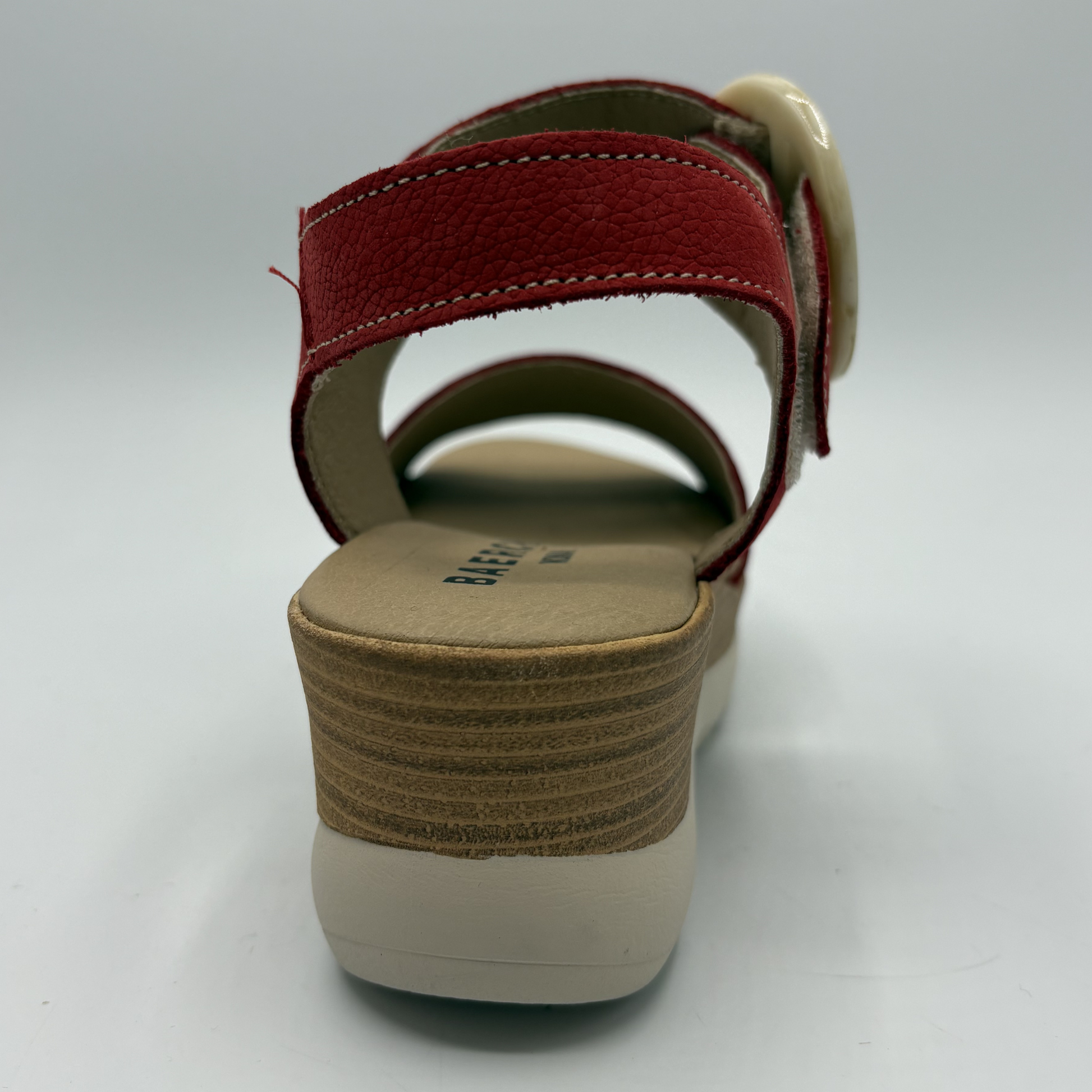 Red sandal with a beige sole on a white background