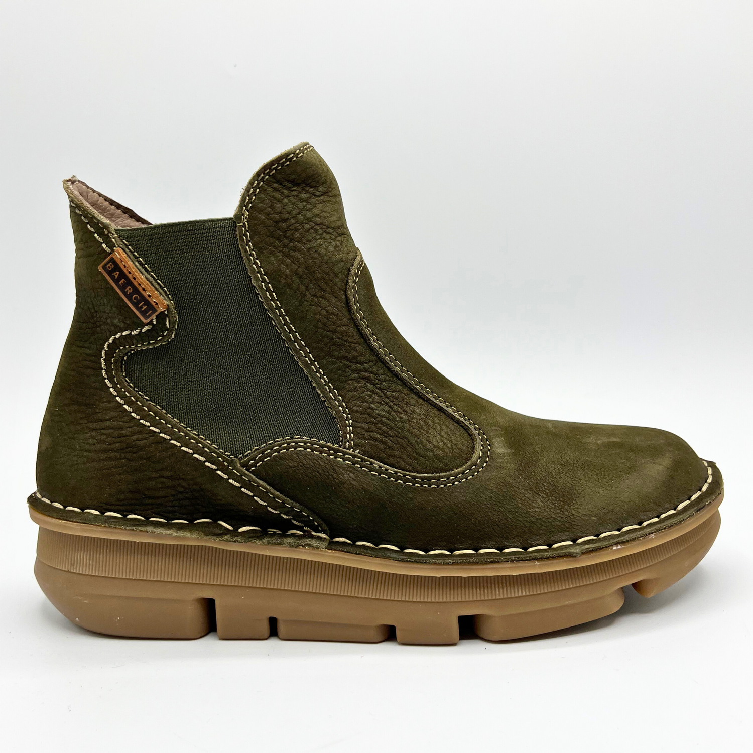 Green ankle boot with brown sole on a white background