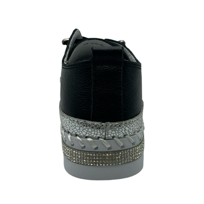 Heel view of black leather sneaker with bejewelled platform sole