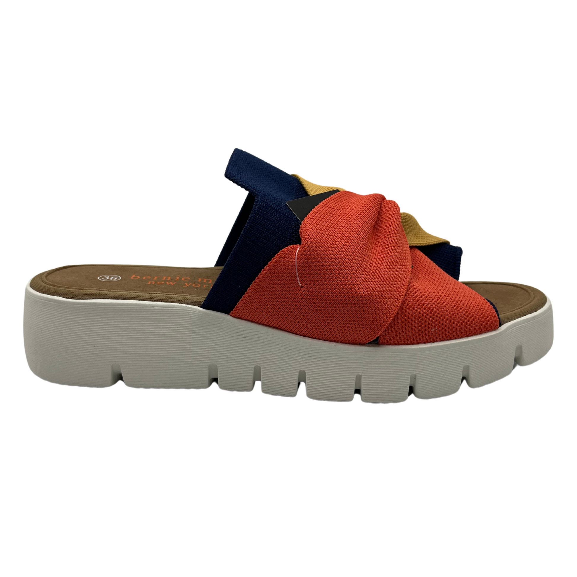 Right facing view of mustard, navy and nectarine elastic strap sandal with white rubber outsole