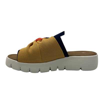 Left facing view of mustard, navy and nectarine elastic strap sandal with white rubber outsole