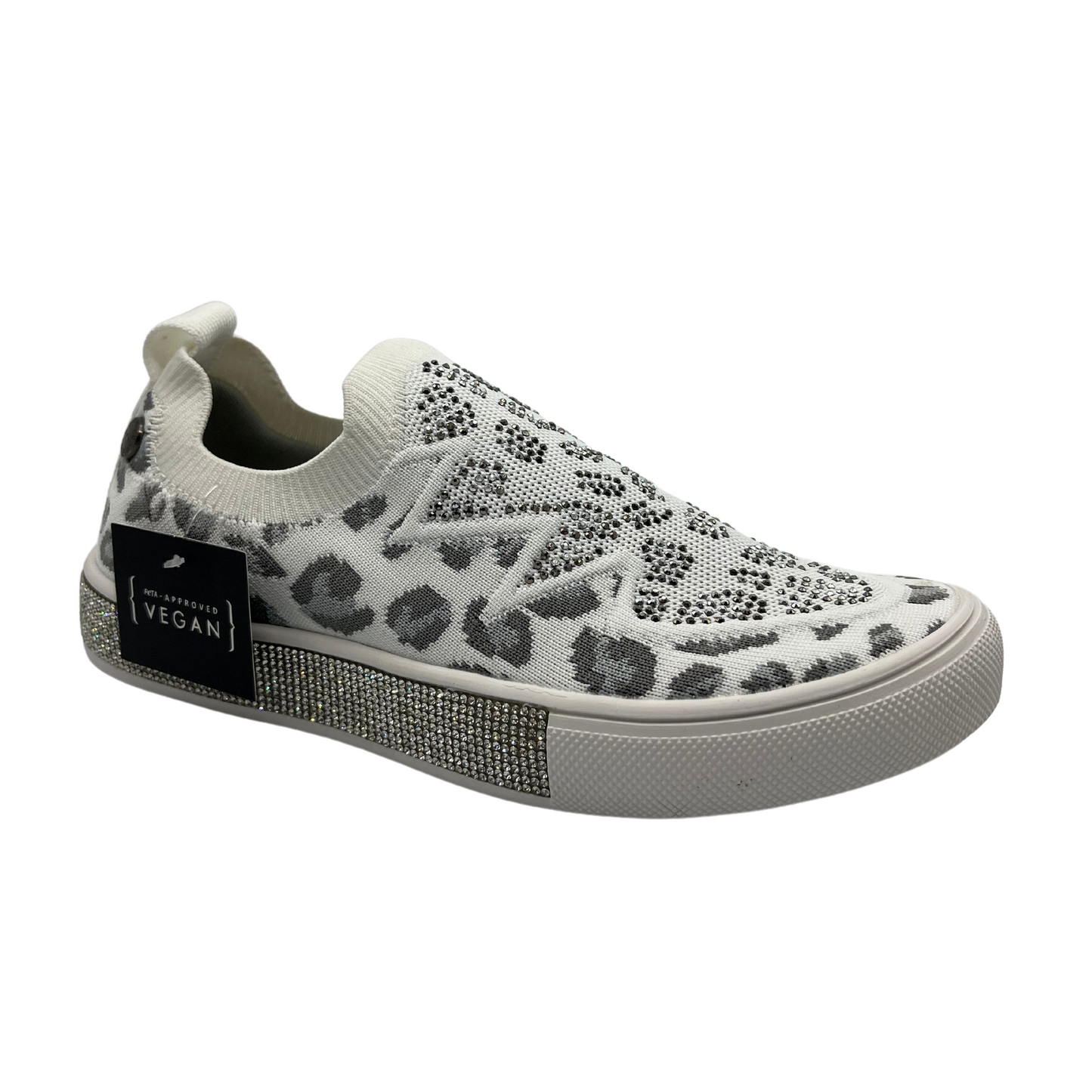 45 degree angled view of a slip on style sneaker in a fun leopard print with silver crystal accents. Shown in white