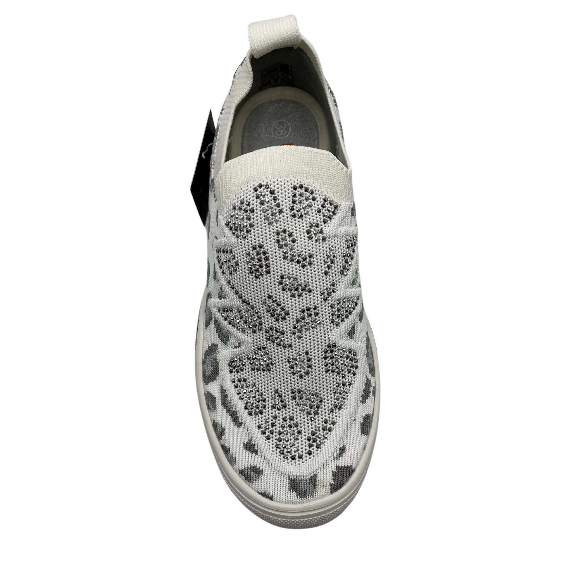 Top view of a slip on style sneaker in a fun leopard print with silver crystal accents. Shown in white
