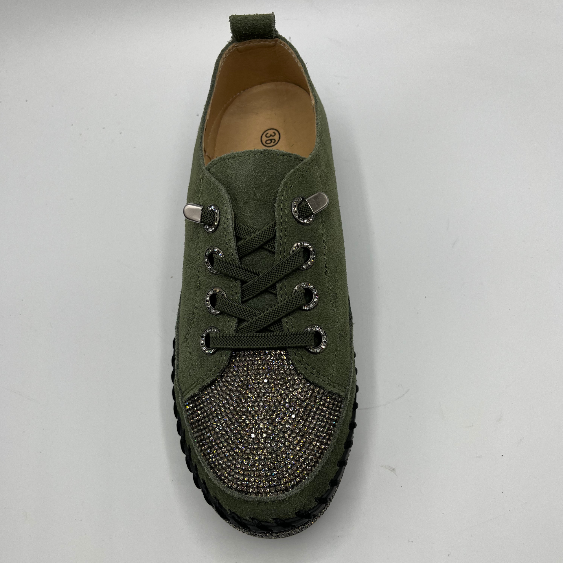 Green sneaker with rhinestone details on a white background