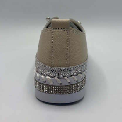 Brown sneaker with decorative silver rhinestone trim on a gray background