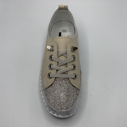 Beige sneaker with rhinestone embellishments on a gray background