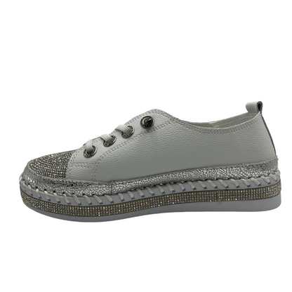 Left facing view of white platform sneaker with bejewelled accents on upper, toe and around the platform sole