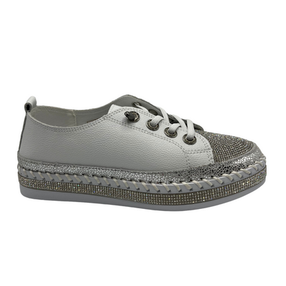 Right facing view of white platform sneaker with bejewelled accents on upper, toe and around the platform sole