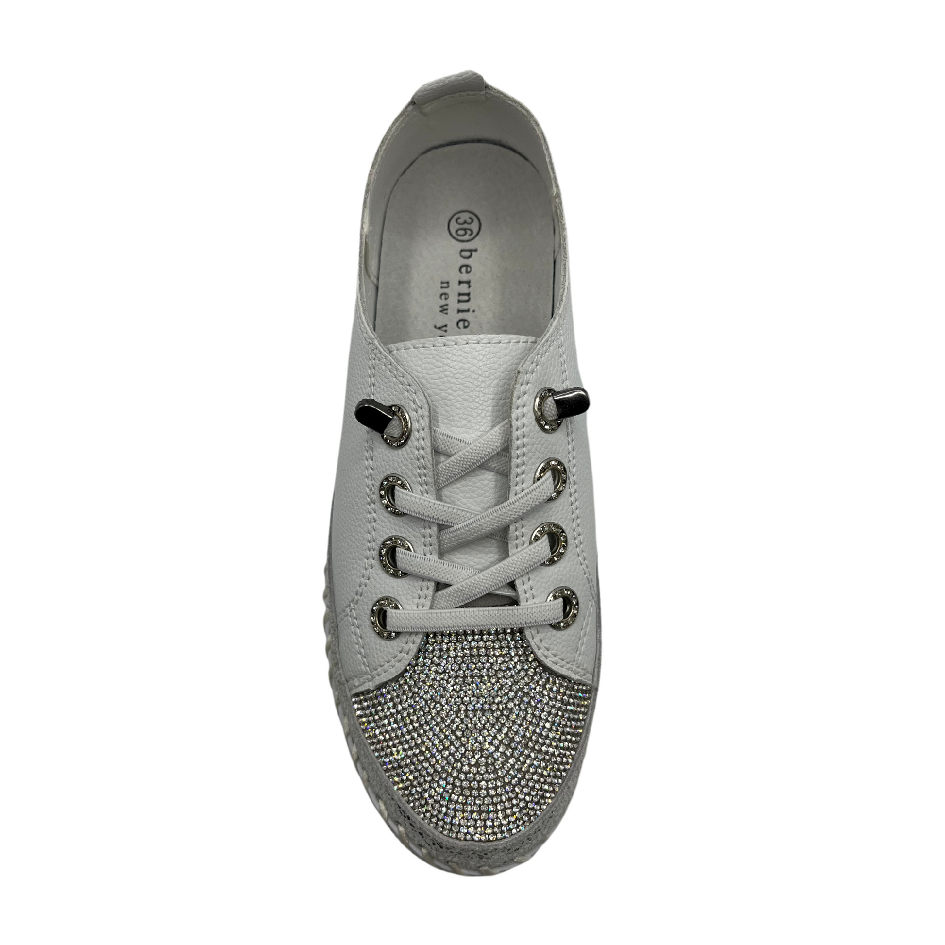 Top view of white platform sneaker with bejewelled accents on upper, toe and around the platform sole