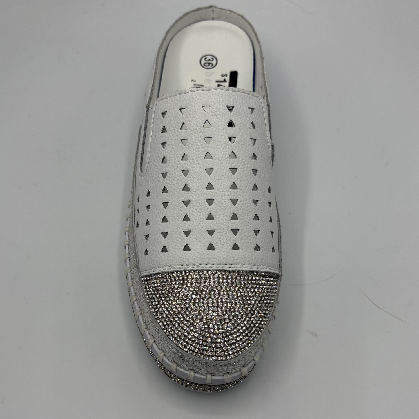 White slip-on shoe with rhinestone embellishments on a gray background
