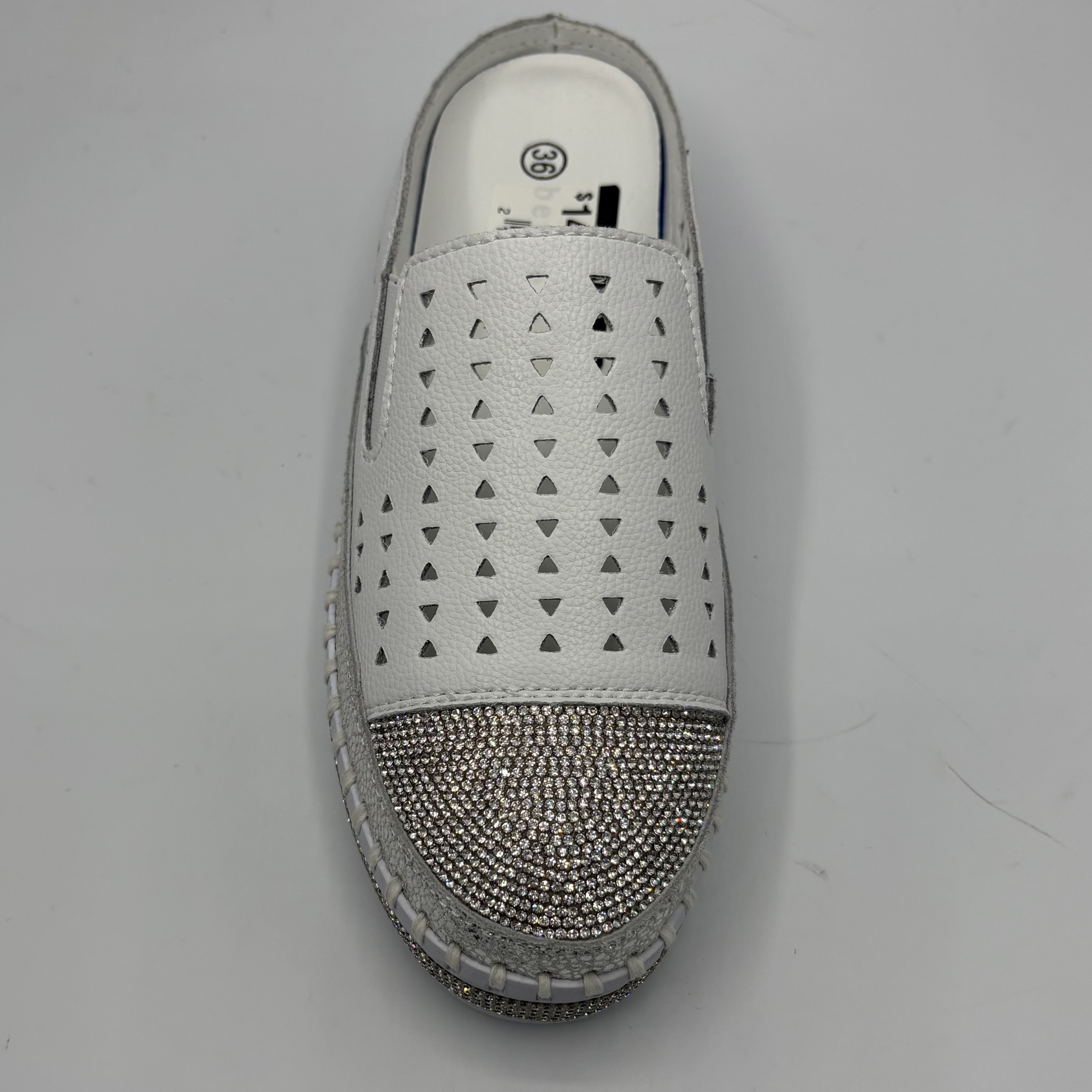 White slip-on shoe with rhinestone embellishments on a gray background