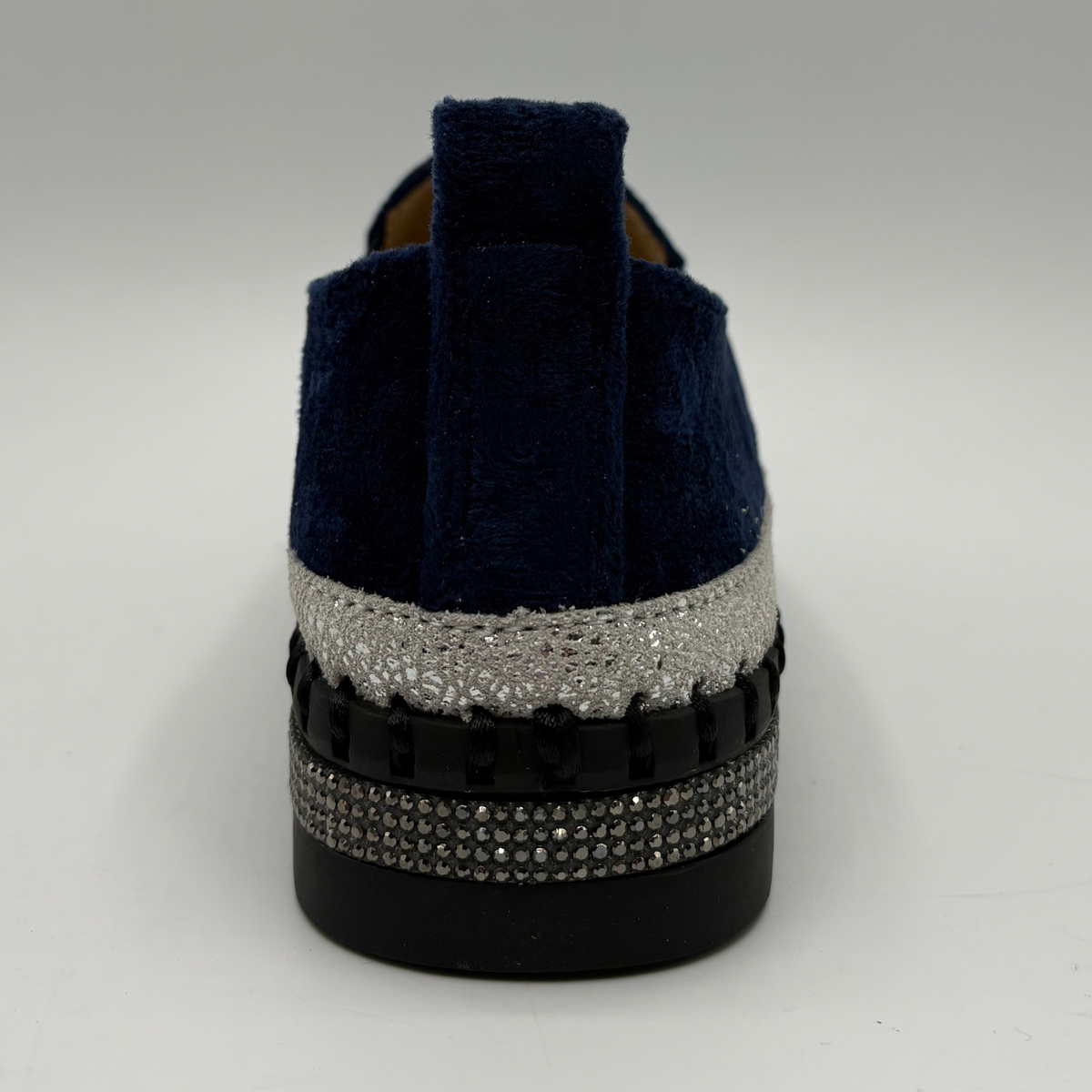 Back view of a navy sneaker with rhinestone embellishments and a platform outsole.