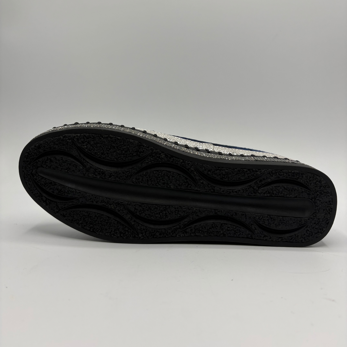 Bottom view of a navy sneaker with rhinestone embellishments and a platform outsole.