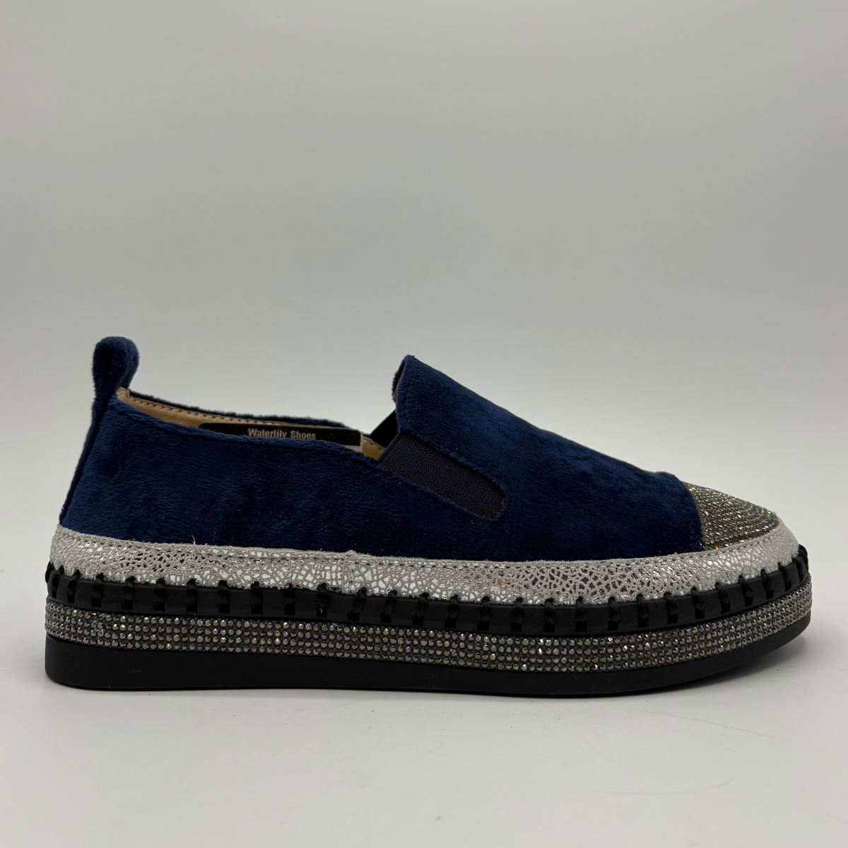Right facing view of a navy sneaker with rhinestone embellishments and a platform outsole.