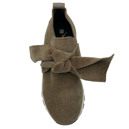 Top view of brown sneaker with large bow detail on upper and pull on tab on heel