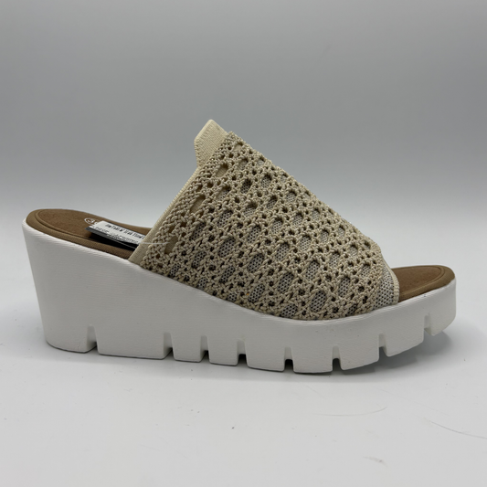 Beige sandal with crochet strap and white sole on a gray background