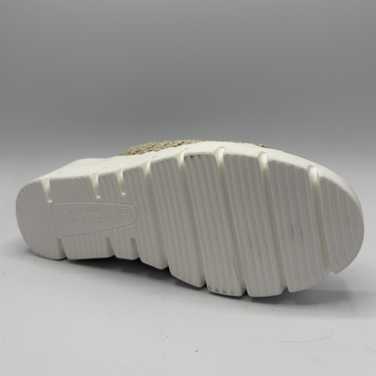 Close-up of a white sole with tread pattern on a gray background