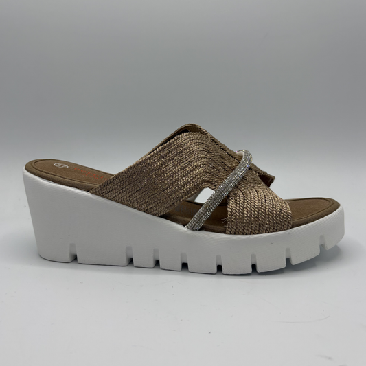 Brown wedge sandal with white sole on a gray background