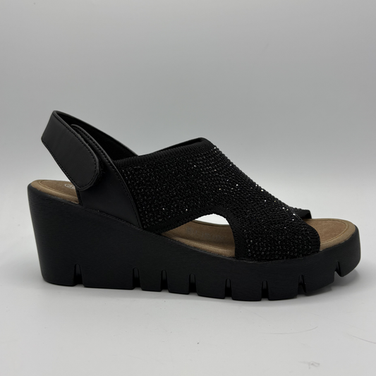Black wedge sandal with rhinestone embellishments on a gray background