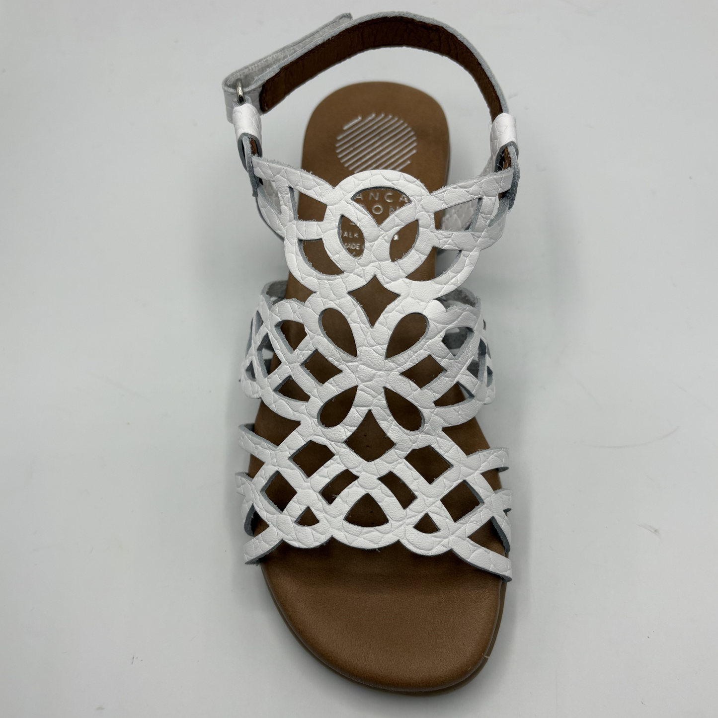 White sandal with brown sole on a light gray background