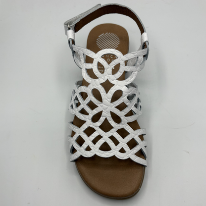 White sandal with brown sole on a light gray background