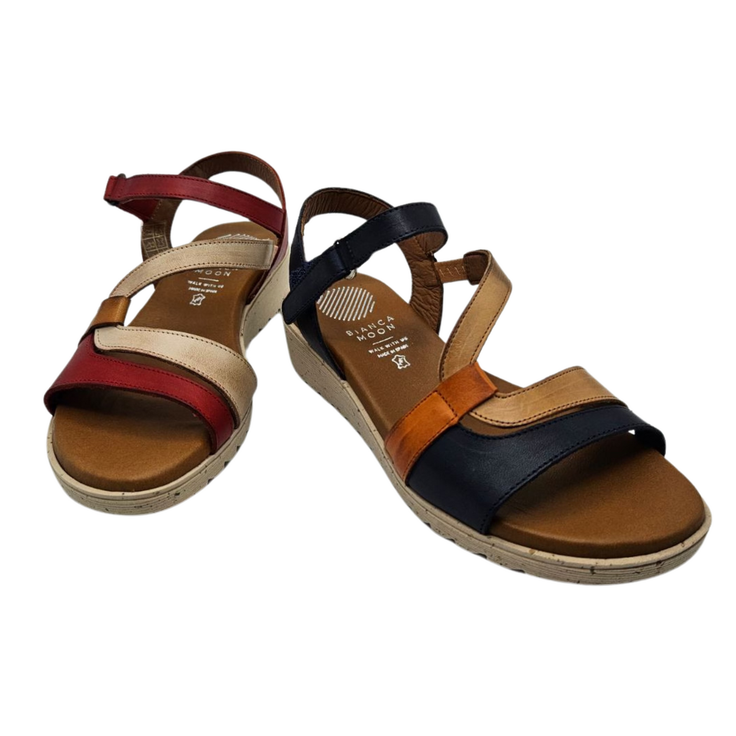 Front view of two leather sandals side by side. The left one is red, cream and brown and the right one is navy, tan and orange. Both have an open toe, velcro ankle strap and a lined footbed