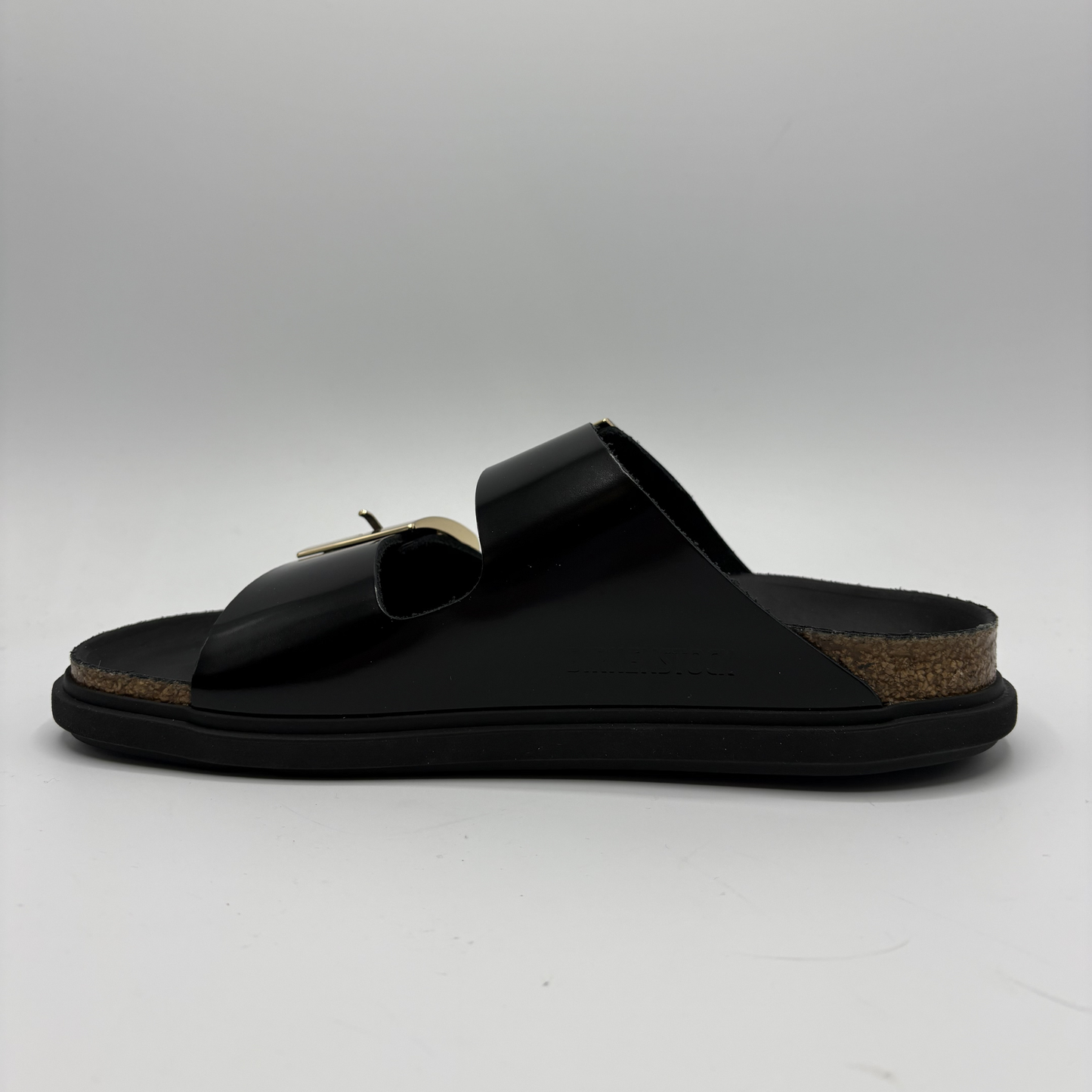 Black sandal with a cork sole on a gray background