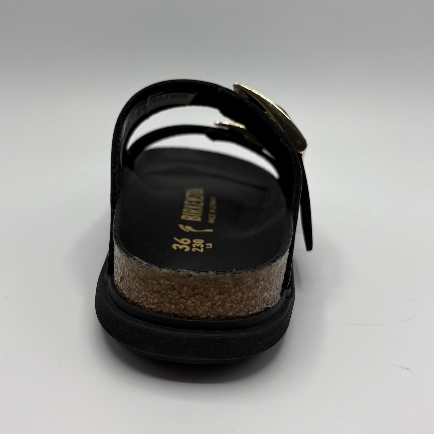 Black sandal with cork sole on a light gray background