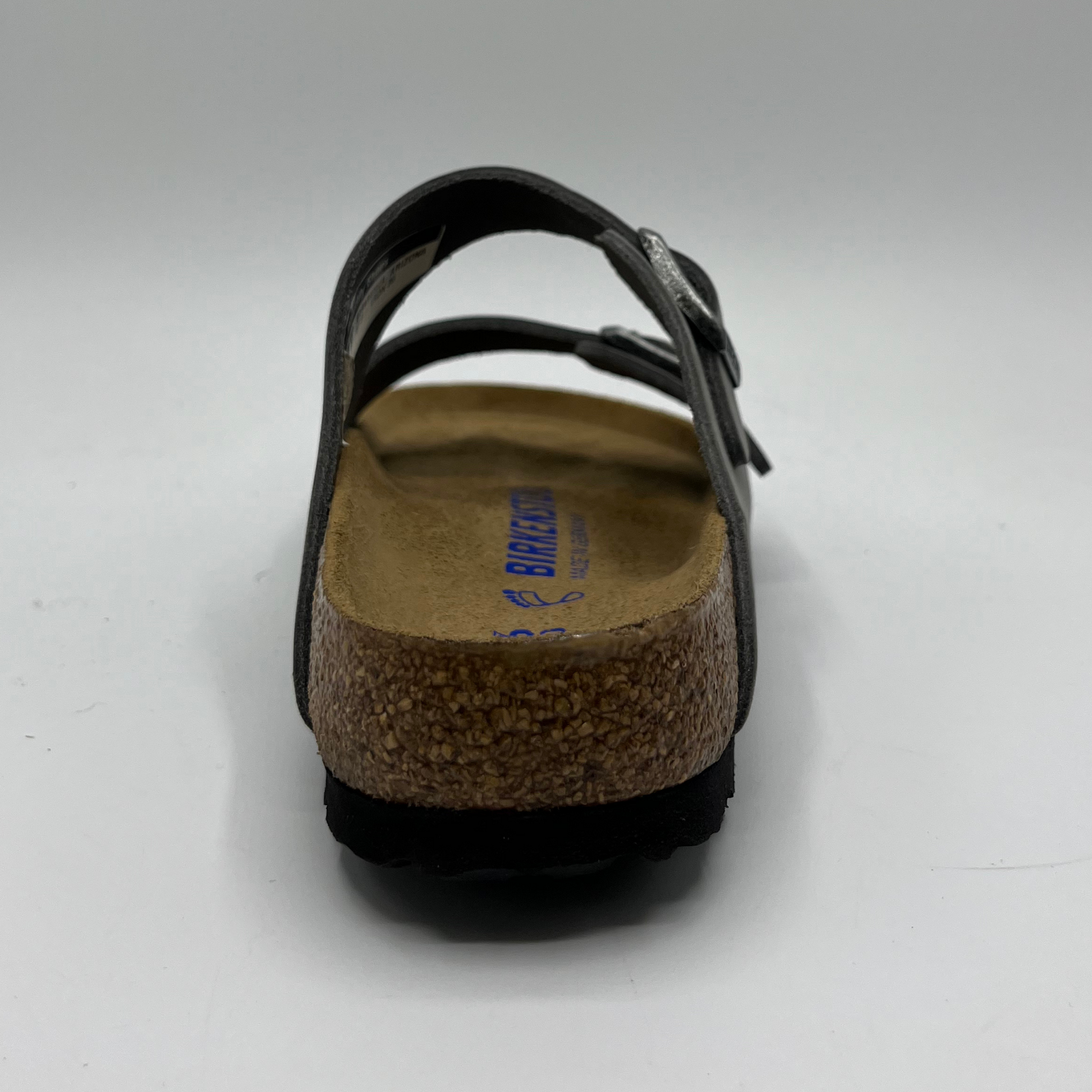Back view of an iron coloured leather sandal with a contoured cork footbed and two adjustable straps.