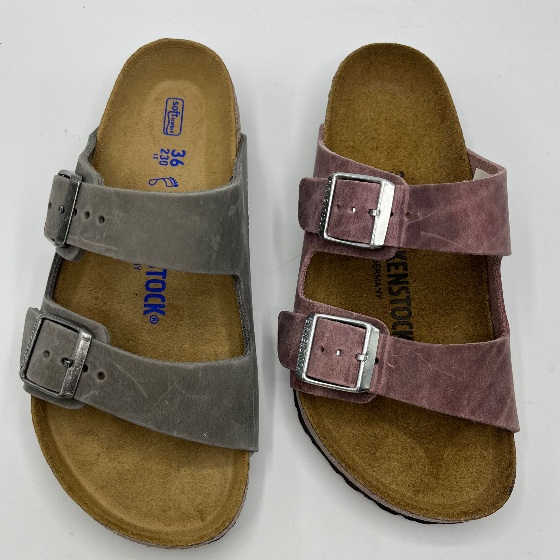 Top view of a two leather sandals side by side. Both have adjustable buckles and a contoured footbed.