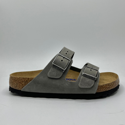 Right facing view of an iron coloured leather sandal with a contoured cork footbed and two adjustable straps.