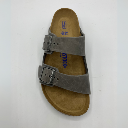 Top view of an iron coloured leather sandal with a contoured cork footbed and two adjustable straps.