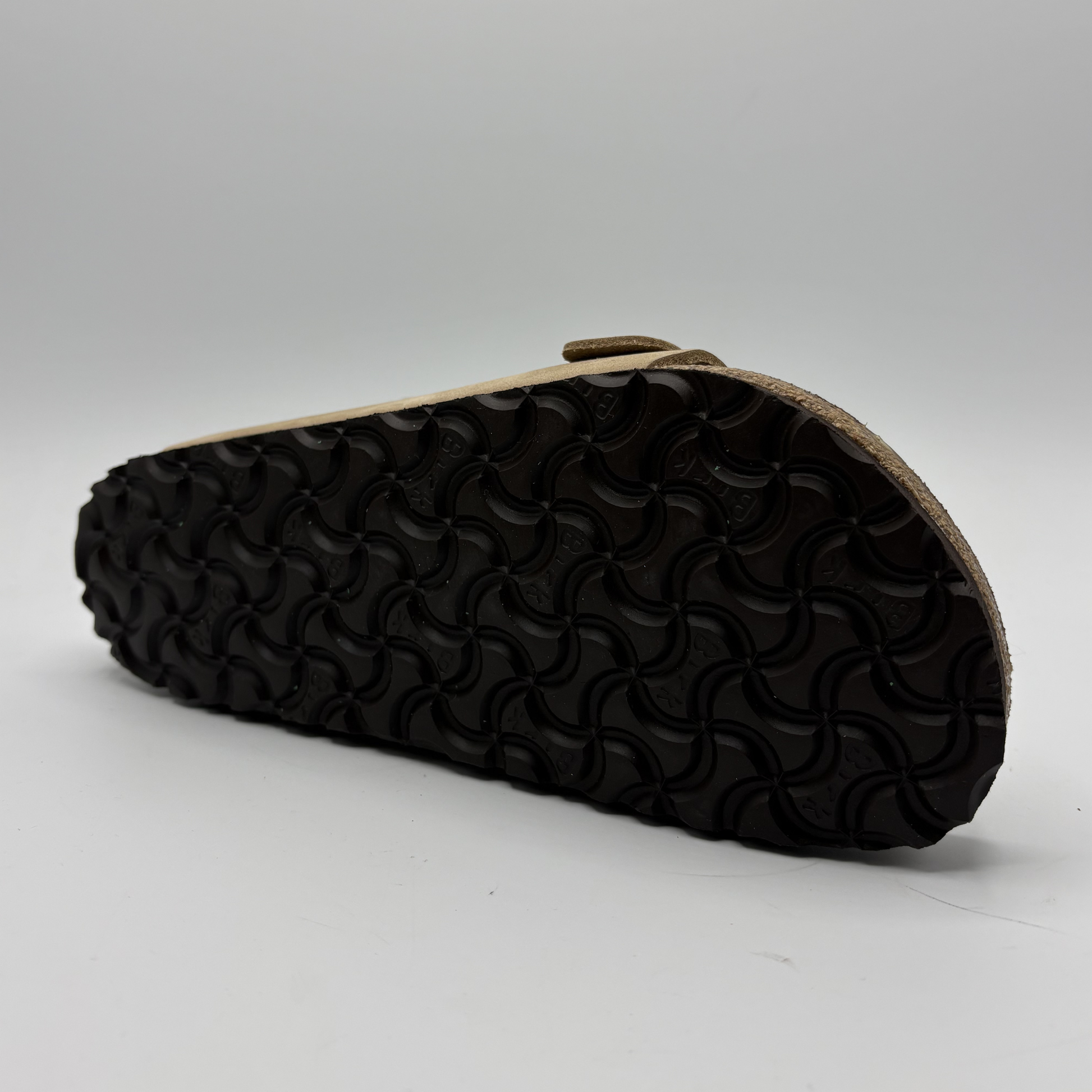 Black sandal sole with wavy pattern on a gray background