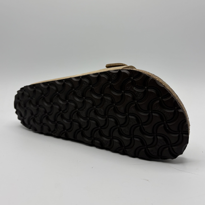 Black sandal sole with wavy pattern on a gray background