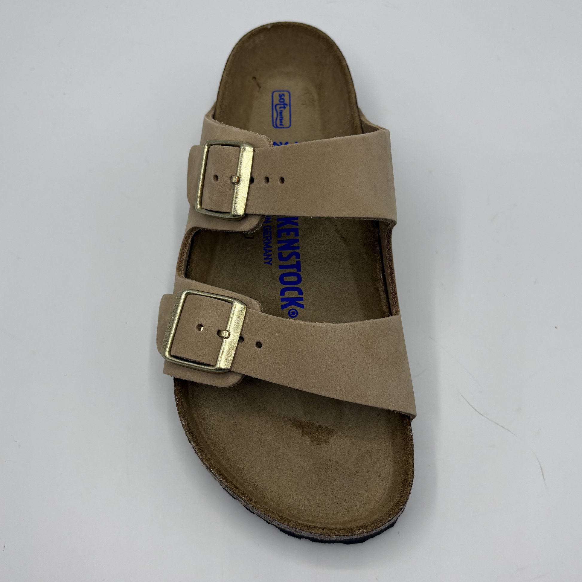 Beige sandal with gold buckles on a white background