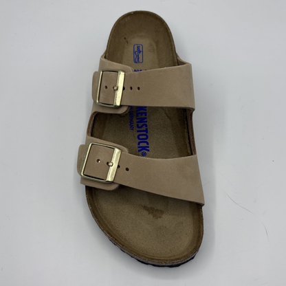 Beige sandal with gold buckles on a white background