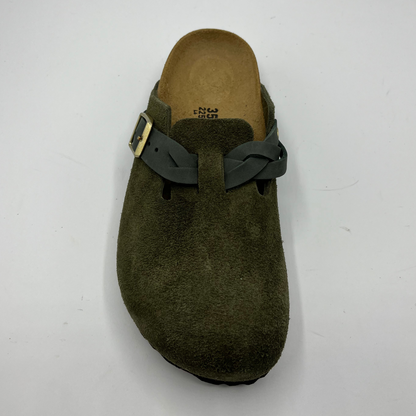 Green clog shoe with a strap on a white background