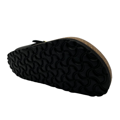 Bottom view of black leather sandals with flower shaped details and adjustable strap