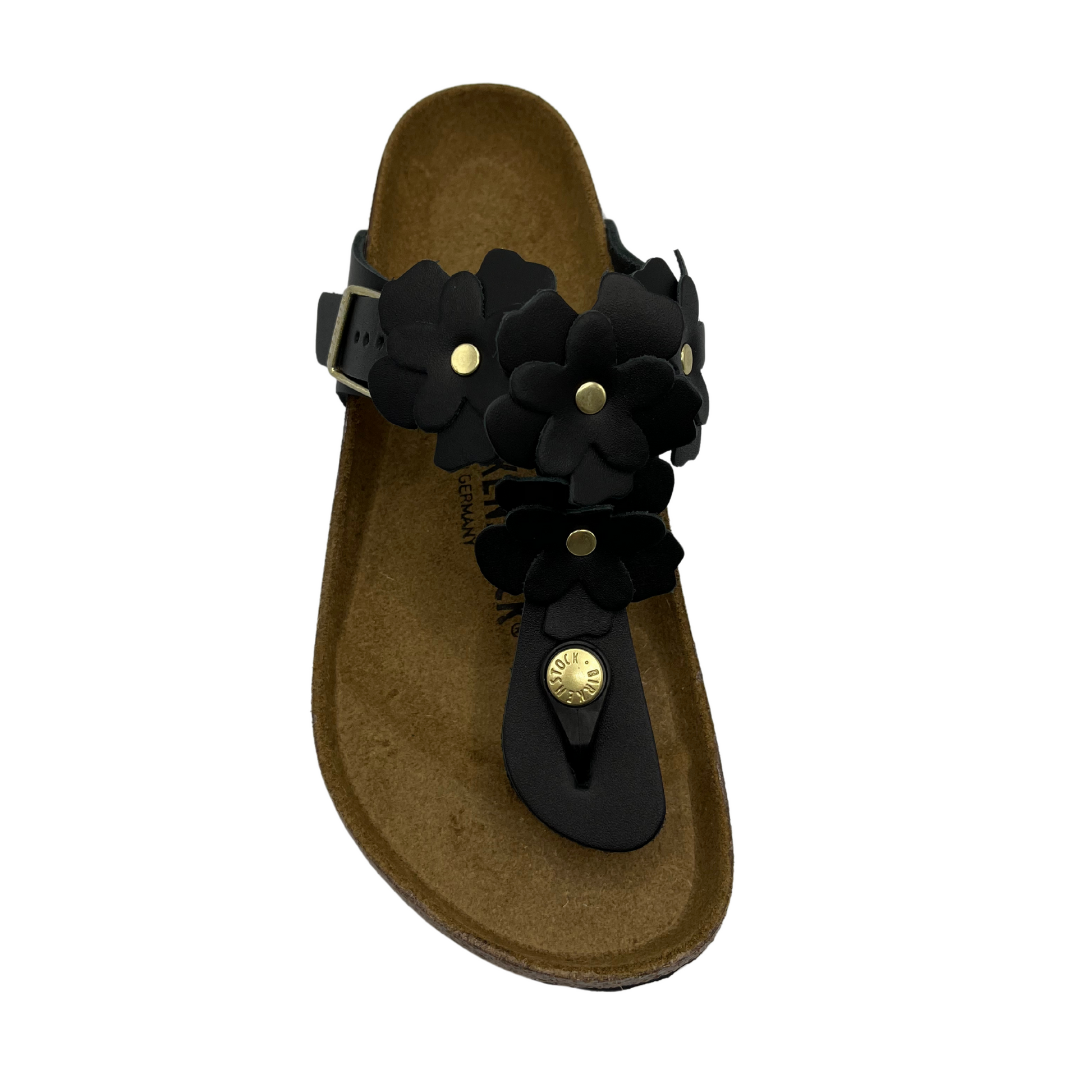 Top view of black leather sandals with flower shaped details and adjustable strap