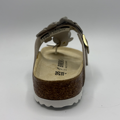 Brown sandal with white sole on a light gray background
